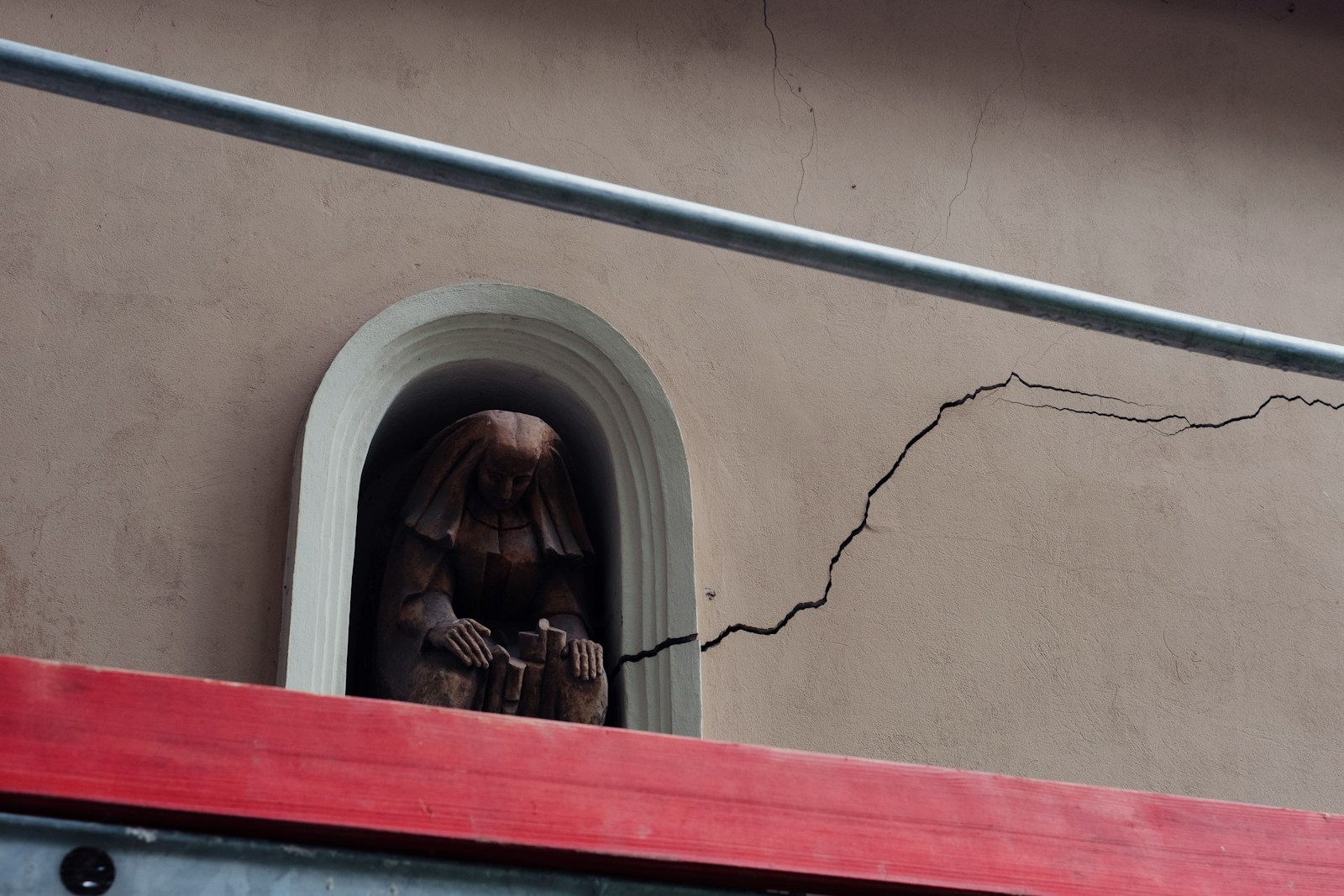 A statue of a woman peeking out of a window - wall repair - drywall - Painting Pros LLC